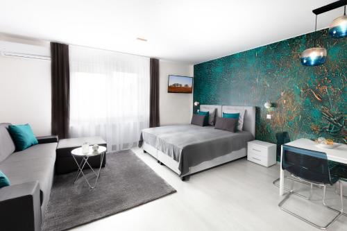 a bedroom with a bed and a couch at Trend Apartmanház -Vizslás in Vizslás