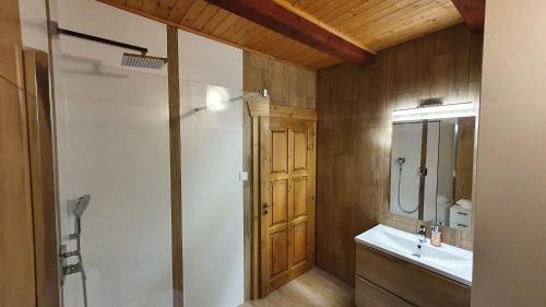 a bathroom with a shower and a sink and a mirror at Chata Panoráma in Námestovo