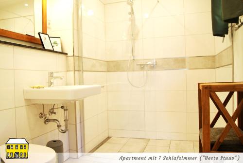 a bathroom with a shower and a sink at Das Gelbe Haus - Drei besondere Ferienwohnungen in Flensburg