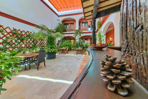 a patio with a table and chairs and a pineapple at Hotel Pozo Rey in Chipiona