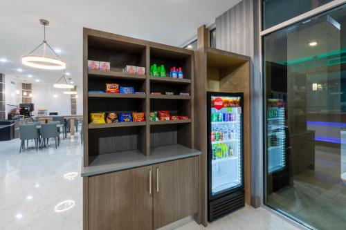 a kitchen with a refrigerator with drinks in it at Days Inn & Suites by Wyndham Downtown/University of Houston in Houston