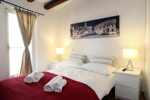 een slaapkamer met 2 witte handdoeken op een bed bij San Teodoro Apartment in Rome