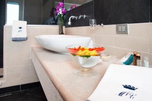 ein Badezimmer mit einem Waschbecken und einer Schüssel Blumen auf der Theke in der Unterkunft Villa Maria Cristina in Caserta