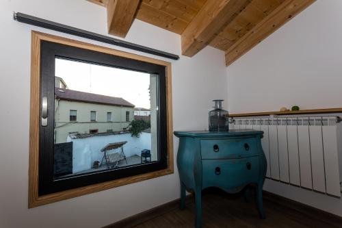 a room with a window and a blue dresser at Apartamentos turísticos 3 Lienzos in Peñafiel
