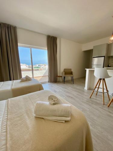 a hotel room with two beds with towels on them at White Sand Apartments Downtown Albufeira in Albufeira