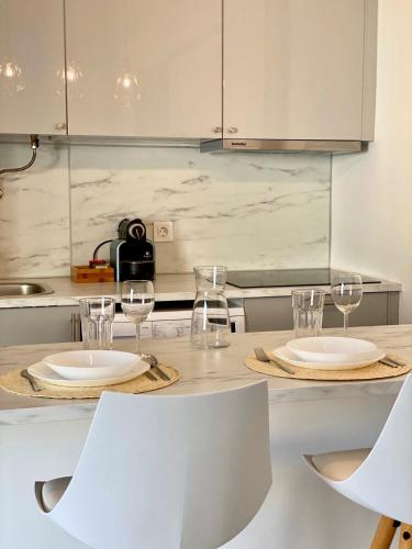 a kitchen with two plates and glasses on a counter at White Sand Apartments Downtown Albufeira in Albufeira