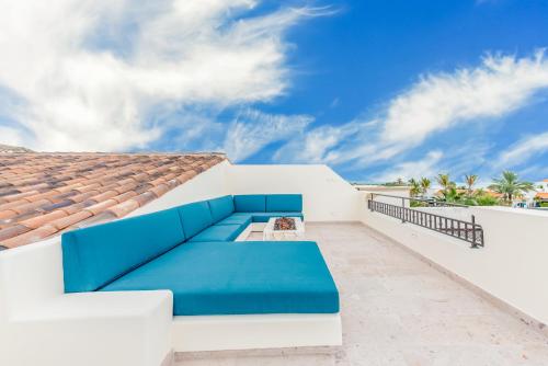 a patio with a blue couch on a white house at Bohari Palmilla in San José del Cabo