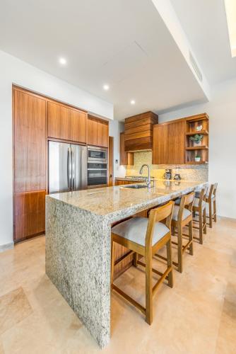 a kitchen with a large marble counter and wooden cabinets at Bohari Palmilla in San José del Cabo