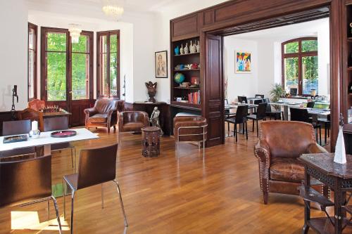 - un salon doté de parquet, de chaises et de tables dans l'établissement Le Manoir d'Agnès, à Tarascon-sur-Ariège