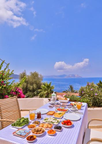 a table with food on it with the ocean in the background at Gardenia Hotel in Kas