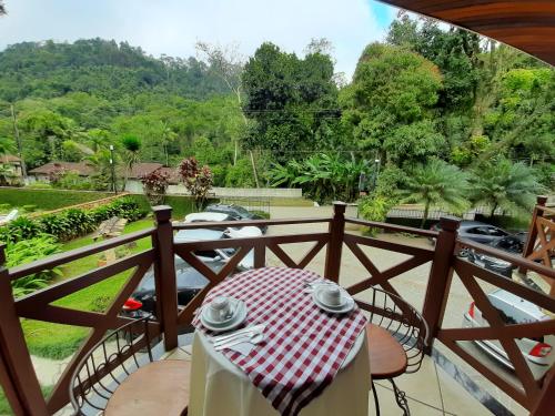 a table with a red and white table cloth on a balcony at Pousada Solar das Montanhas in Penedo