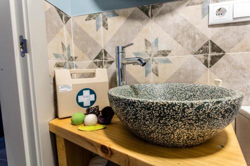 a bathroom sink sitting on a wooden counter next to a wall at Apartamentos turísticos 3 Lienzos in Peñafiel