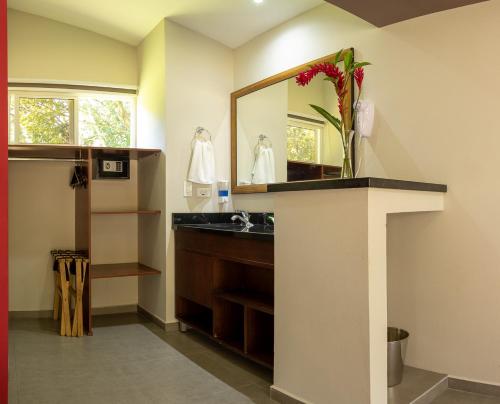 a bathroom with a sink and a mirror at Guácima Escondida Hotel Boutique in Guácima