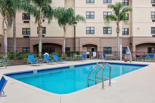 a swimming pool in front of a building with palm trees at Extended Stay America Premier Suites - Lakeland - I-4 in Lakeland