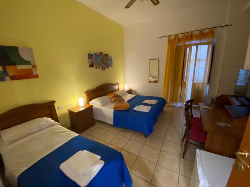 a hotel room with two beds and a window at Gli Agrumi Rooms in Trapani