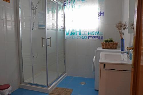 La salle de bains est pourvue d'une douche en verre et d'un lavabo. dans l'établissement La casina de ribadesella 5 personas, à Ribadesella