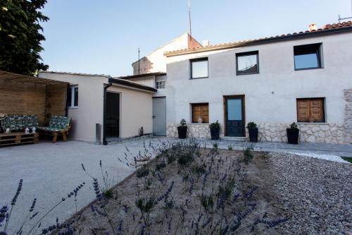 a large white house with a patio in front of it at Apartamentos turísticos 3 Lienzos in Peñafiel