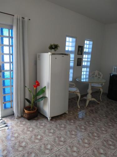 布羅塔斯的住宿－Casa da Lili-ESPAÇO INDEPENDENTE E PRIVATIVO，一张桌子的房间里,有白色的冰箱