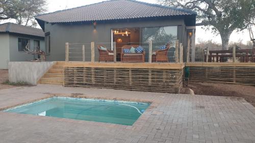 a house with a deck and a swimming pool at Antares Bush Camp & Umgede Hide in Grietjie Nature Reserve
