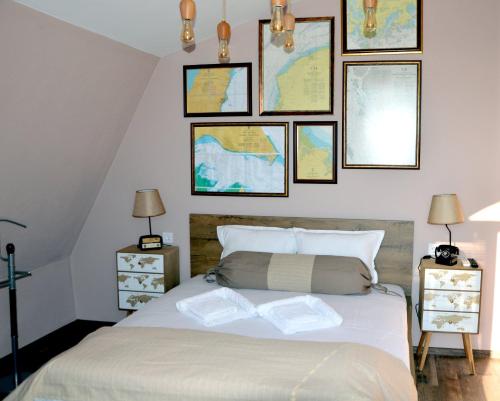 a bedroom with a bed with pictures on the wall at Boutique Villa Amalia in Chernomorets
