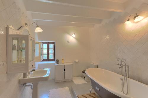 a bathroom with a tub, sink, toilet and bathtub at Can Quince de Balafia - Turismo de Interior in Sant Llorenç de Balafia
