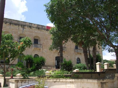 a large stone building with trees in front of it at Door Eight in Il-Furjana