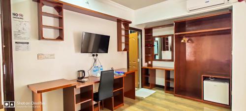 a room with a desk and a tv on a wall at Athens View Hotel in Guraidhoo