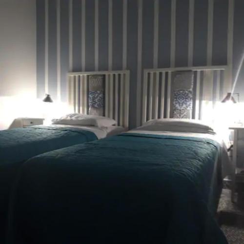 two beds in a bedroom with striped walls at Door Eight in Il-Furjana