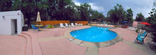 a large swimming pool with chairs and a table at Buffalo Lodge Bicycle Resort - Amazing access to local trails & the Garden in Colorado Springs