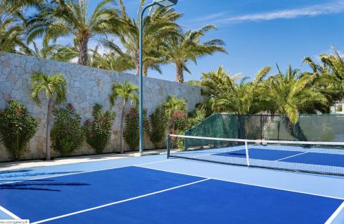 a tennis court with palm trees in the background at Bohari Palmilla in San José del Cabo
