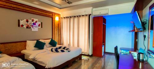 a hotel room with two beds and a window at Athens View Hotel in Guraidhoo