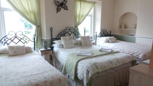 a bedroom with two beds and a window at Tynedale Guest House in Penrith