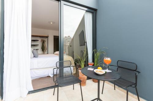 a room with a table and chairs and a bed at Stay Suites in Cordoba
