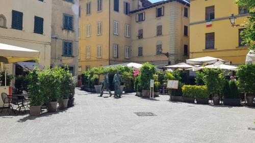 a courtyard with potted plants and tables and buildings at Palazzo 42 - Boutique Hotel & Suites in Pistoia