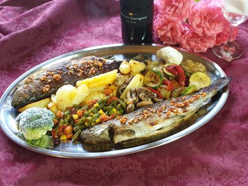 a plate of food with fish and vegetables on a table at Pansion Breza in Plitvička Jezera