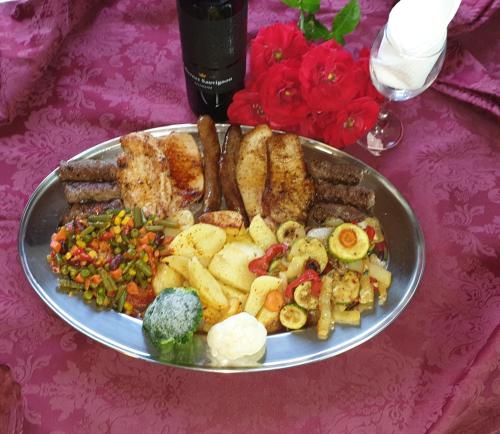 a plate of food with sausage and vegetables on a table at Pansion Breza in Plitvička Jezera