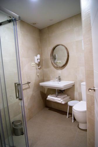 a bathroom with a sink and a toilet and a mirror at Hotel La Encomienda in Moraleja