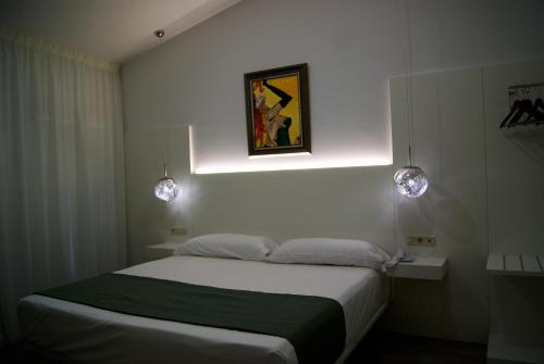 a bedroom with a bed and a painting on the wall at Hotel La Encomienda in Moraleja