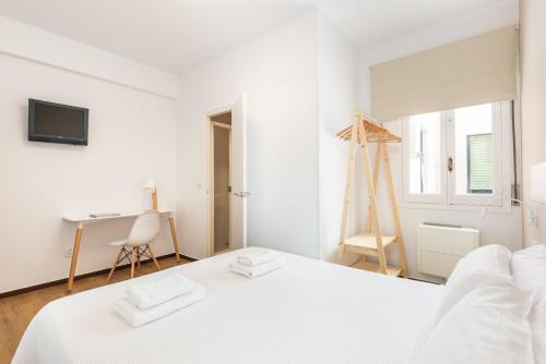 a bed room with a white bedspread and a white dresser at Hostal Jume - Urban Rooms in Mahón