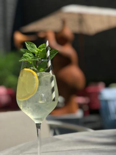 a drink with a lime and a striped straw at Boutique Hotel Sablon by CW Hotel Collection in Bruges