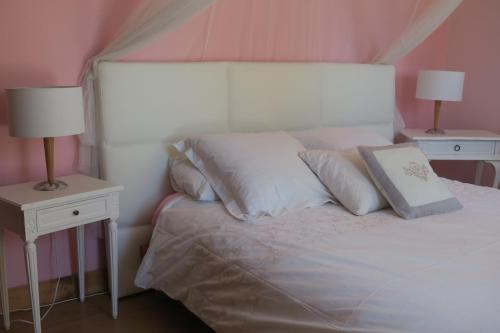 a bedroom with a white bed with two night stands at B&B Le Patio En Ville - Chambres d'hôtes in Narbonne