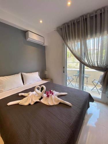 two swans towels on a bed in a bedroom at JUEL APARTMENTS in Pefkochori