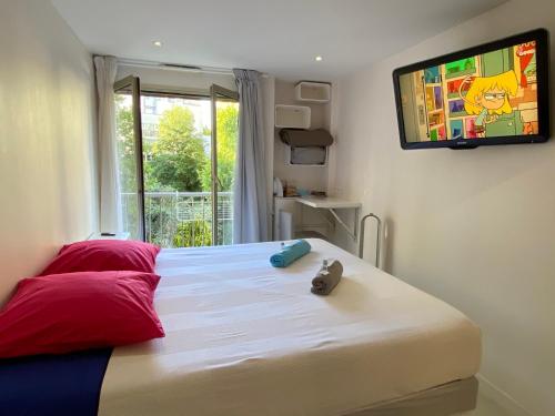 a bedroom with a bed with a television on the wall at Paris Canal Studio - Gare de l'Est in Paris