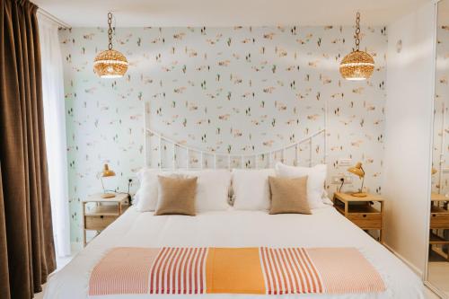 Hotel Mar Azul & Surf في سوانسيس: غرفة نوم مع سرير أبيض وورق جدران طيور