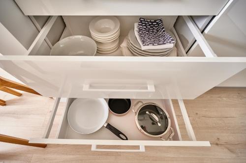 奥尔什丁Apartament Dwa Jeziora的装满盘子、碗和盘子的橱柜