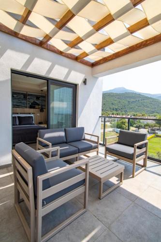 a patio with couches and chairs on a balcony at MAIA Luxury Beach Hotel & Spa in Guzelcamlı