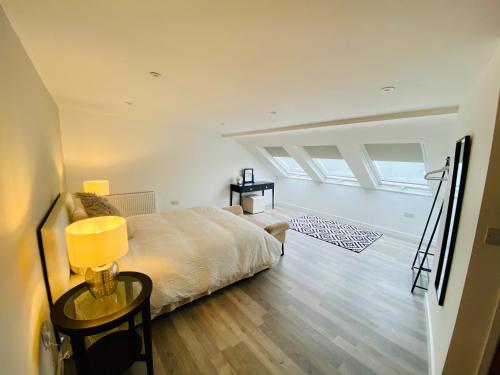 a bedroom with a bed and a table with a lamp at New home with stunning views of the Menai Straits in Llanedwen