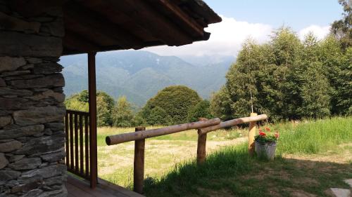 a porch with a fence and a bucket of flowers at Le Baite di Baudinet - Trek&Relax in Chiusa di Pesio