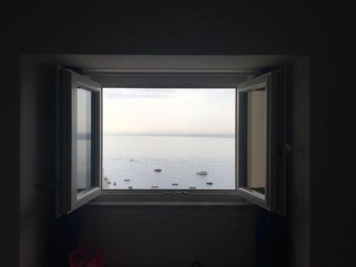 an open window with a view of the ocean at Maison Raphael Positano in Positano