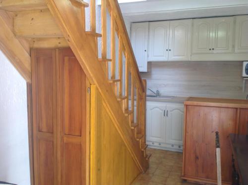 a kitchen with a wooden staircase leading up to a kitchen at A.Casetta in Santo-Pietro-di-Venaco